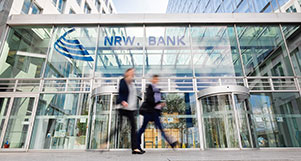 Ein Mann und eine Frau gehen am NRW.BANK-Gebäude vorbei