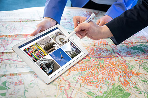 Das Bild zeigt ein Tablet mit Bildern von verschiedenen von der NRW.BANK geförderten Projekten zur Verbesserung der Infrastruktur.