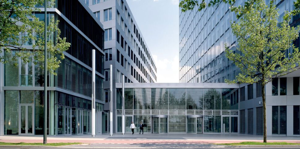 Der Eingangsbereich der NRW.BANK-Zentrale in Düsseldorf von außen, mit großer Fensterfront und Drehtüren