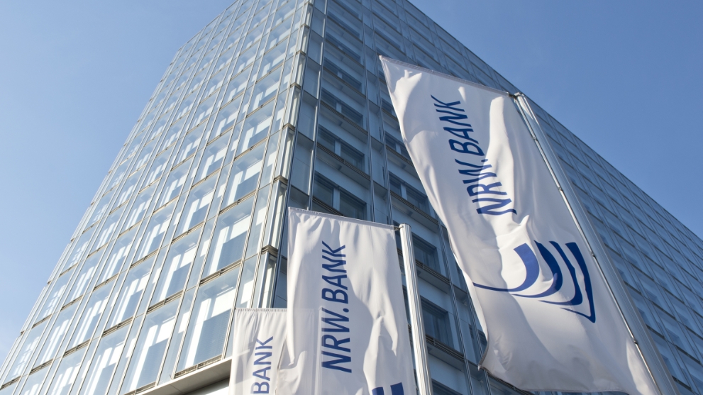 Hochhaus mit Fensterfassade, davor wehen Fahnen der NRW.BANK