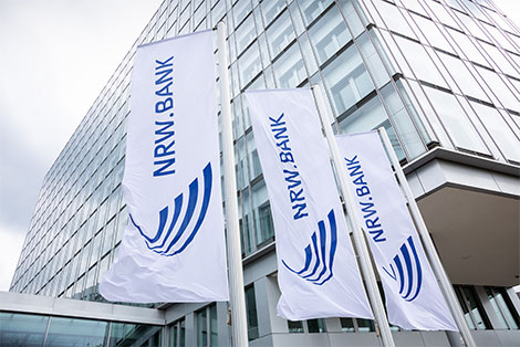 Die Firmenzentrale der NRW.BANK, davor wehende Fahnen mit dem Logo der Bank