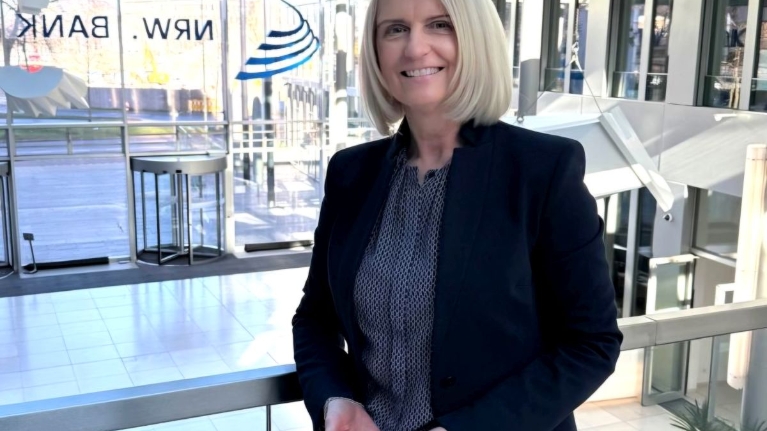 Die Förderberaterin Claudia Brendt zeigt die Geste zum Weltfrauentag 2026 unter dem Motto "Give To Gain".