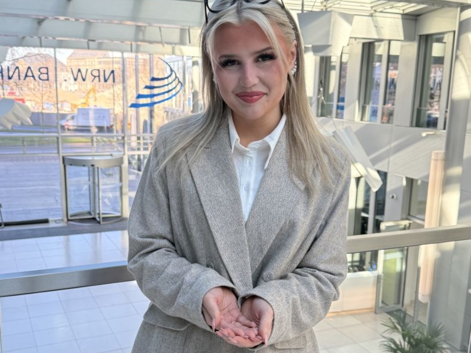 Die Förderberaterin Denise-Sophie Lorenzen zeigt die Geste zum Weltfrauentag 2026 unter dem Motto "Give To Gain".