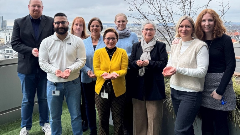 Mitarbeitende der NRW.BANK zeigen die Geste zum Weltfrauentag 2026 unter dem Motto "Give To Gain".