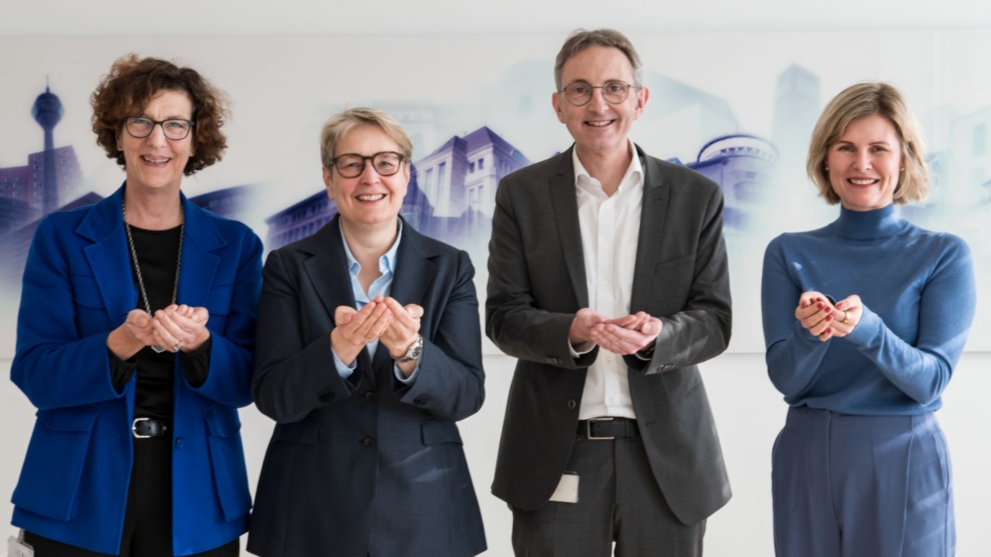 Die Vorstände der NRW.BANK zeigen die Geste zum Weltfrauentag 2026 unter dem Motto "Give To Gain".