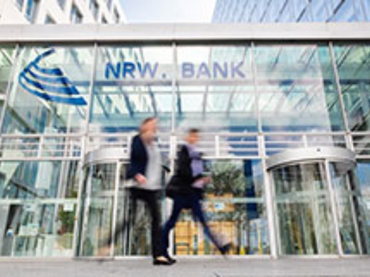 Ein Mann und eine Frau gehen am NRW.BANK-Gebäude vorbei