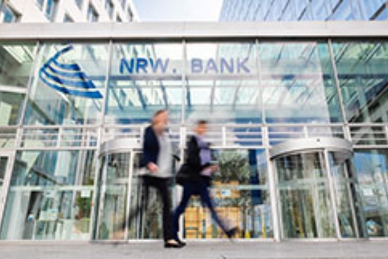 Ein Mann und eine Frau gehen am NRW.BANK-Gebäude vorbei