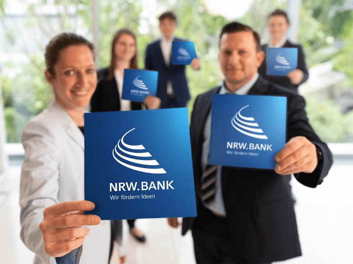 Fünf Mitarbeiterinnen und Mitarbeiter der NRW.BANK heißen neue Kolleginnen und Kollegen herzlich willkommen.