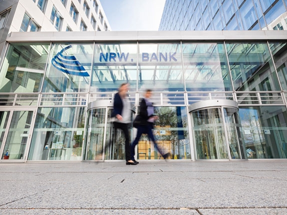 Zwei Mitarbeitende gehe an der NRW.BANK vorbei.