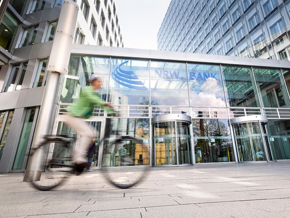 Eine Frau fährt mit ihrem Fahrrad an der NRW.BANK vorbei.
