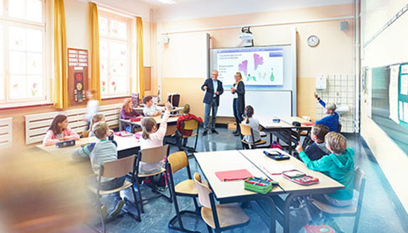 Zwei Lehrer unterrichten Schüler in einem modernen Klassenraum