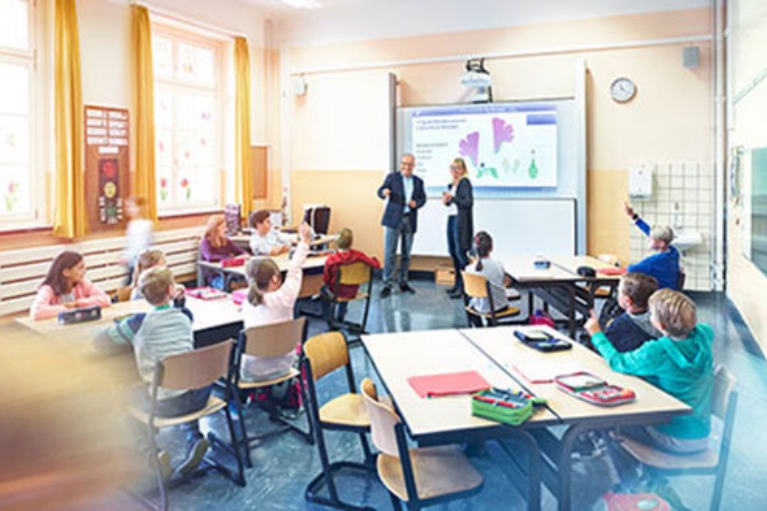 Zwei Lehrer unterrichten Schüler in einem modernen Klassenraum