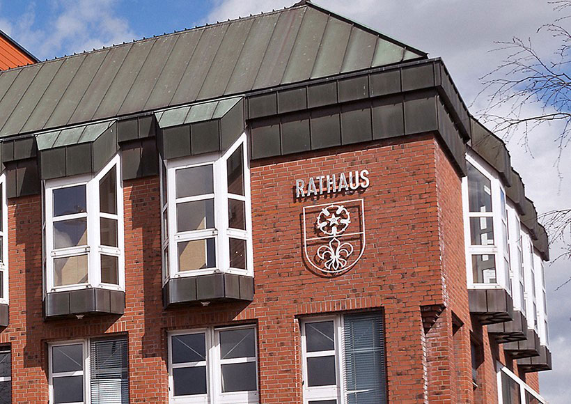 Außenansicht des Rathauses in Kevelaer mit rotem Backstein, Stadtwappen und Schriftzug Rathaus