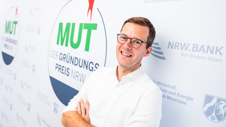 Philipp Soest von cleansort vor dem MUT - DER GRÜNDUNGSPREIS NRW-Logo