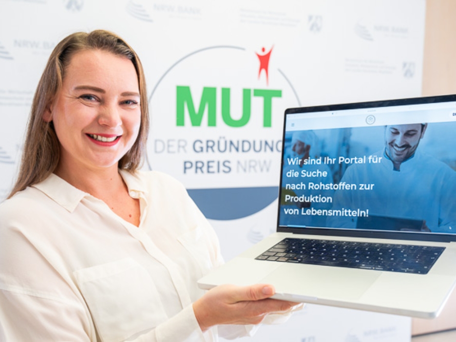 Marina Billinger von Leroma vor dem MUT - DER GRÜNDUNGSPREIS NRW-Logo