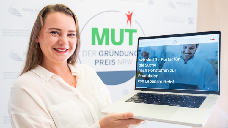 Marina Billinger von Leroma vor dem MUT - DER GRÜNDUNGSPREIS NRW-Logo