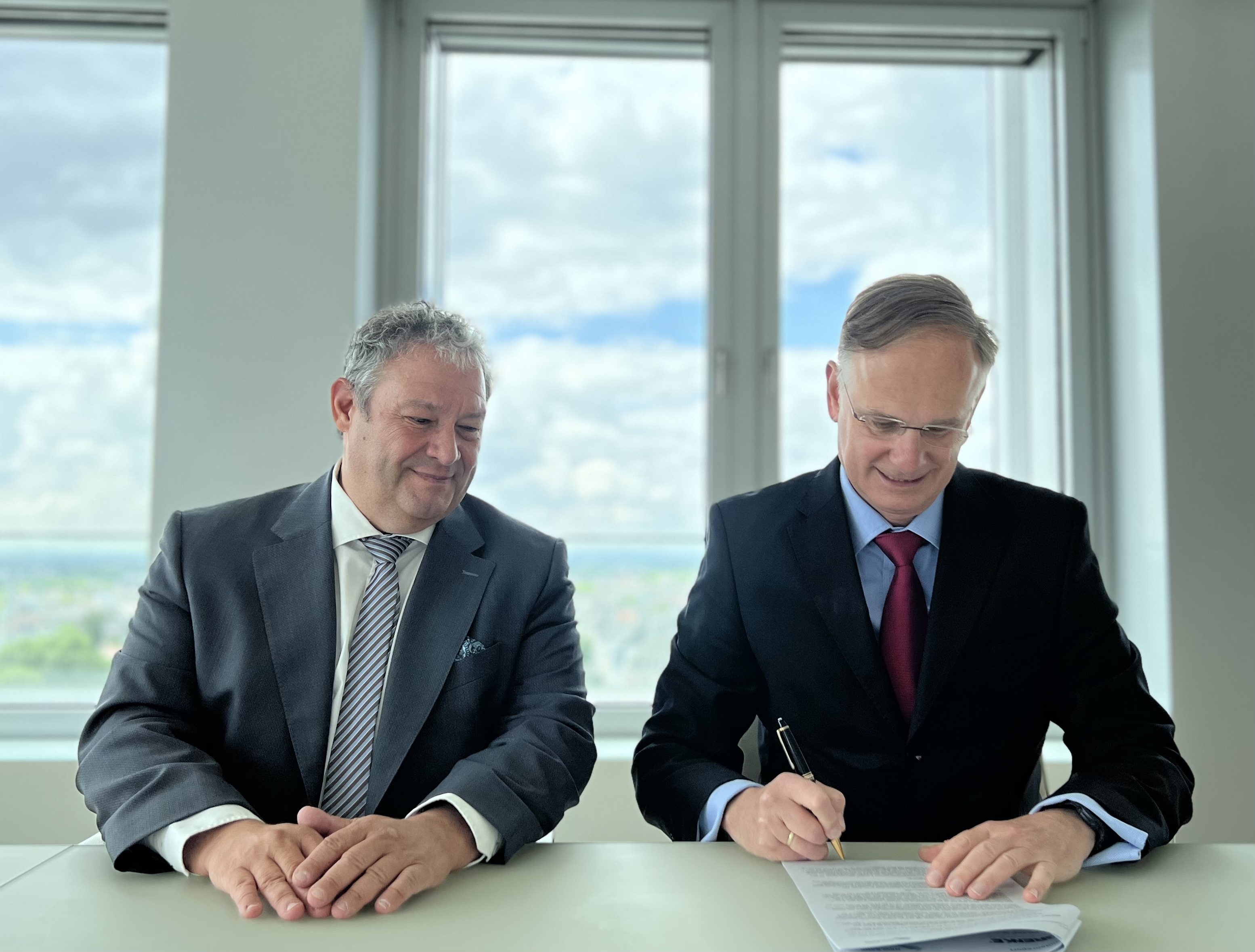 Helge Krame, Vorstand Markt der GRENKE AG, und Michael Stölting, Vorstandsmitglied der NRW.BANK, unterzeichnen den gemeinsamen Vertrag fürs neue Globaldarlehen.