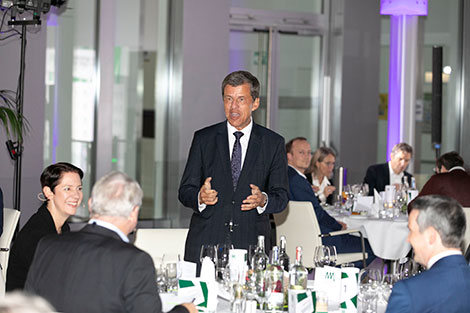 NRW.BANK-Vorstandsvorsitzender Eckhard Forst hält, an einem festlich gedeckten Tisch stehend, eine Rede.