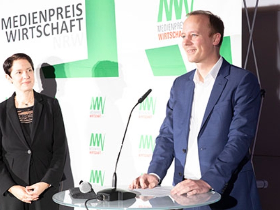 NRW-Landwirtschaftsministerin Silke Gorißen steht neben Florian Rinke, der eine Laudatio hält.