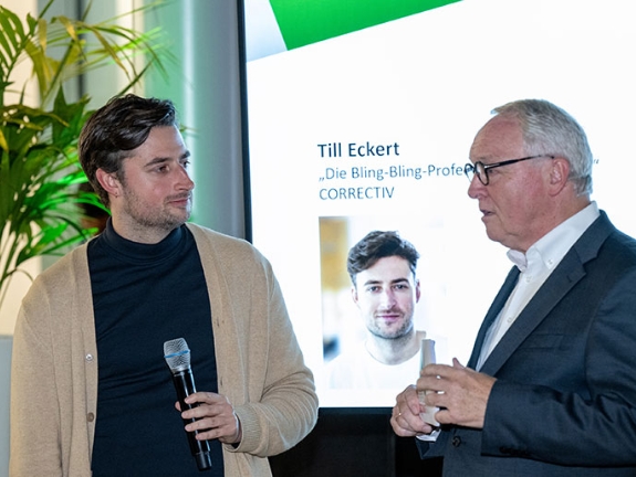 Tobias Eckert steht mit Norbert Tiemann vor einem Bildschirm