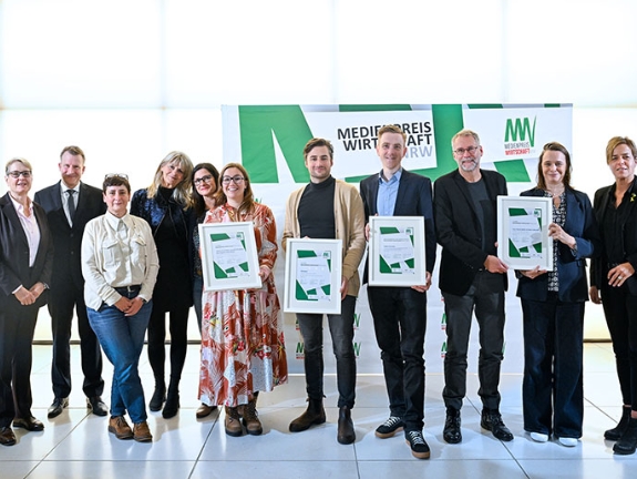 Die Preisträgerinnen und Preisträger des MEDIENPREIS WIRTSCHAFT NRW 2024 Helga Szentpéteri, Ursula Welter, Nina Voigt, Annabell Brockhues, Till Eckert, Tobias Fenneker, Claus Hanischdörfer und Tatjana Mischke (von links) mit Gabriela Pantring (links vorne), stellvertretende Vorsitzende des Vorstands der NRW.BANK, Edzard Bennmann (links hinten), Leiter Unternehmenskommunikation der SIGNAL IDUNA Gruppe, und Wirtschafts- und Klimaschutzministerin Mona Neubaur (rechts)