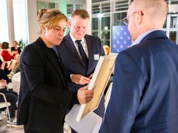 Ministerin Mona Neubaur überreicht eine Urkunde