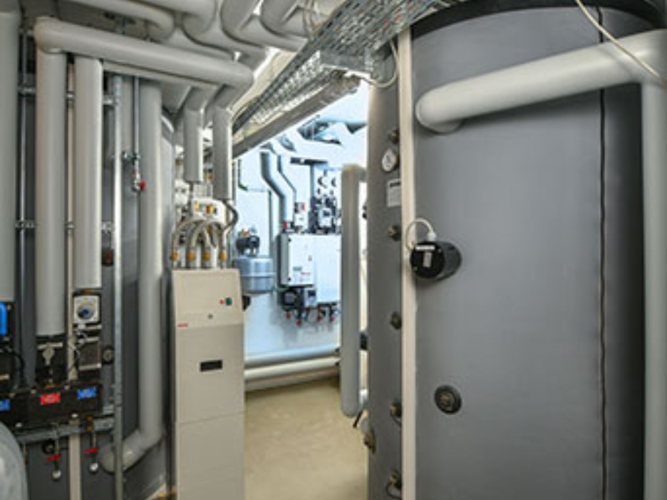 Technikraum mit Leitungen, Wärmepumpen und großen Pufferspeichern.