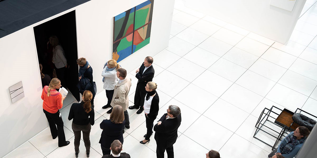 Eine Gruppe von Menschen bei einer Führung durch eine Kunstausstellung