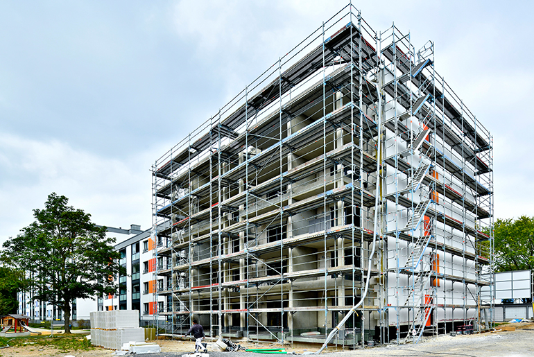 Ein mehrstöckiges Haus, das von Baugerüsten umgeben ist