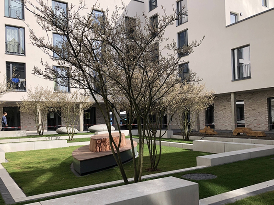 Idyllischer Innenhof eines Studierendenwohnheims mit Sitzgelegenheiten und Pflanzen