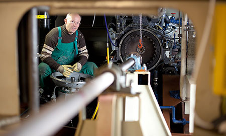 Ein Mann sitzt im Maschinenraum einer Fähre