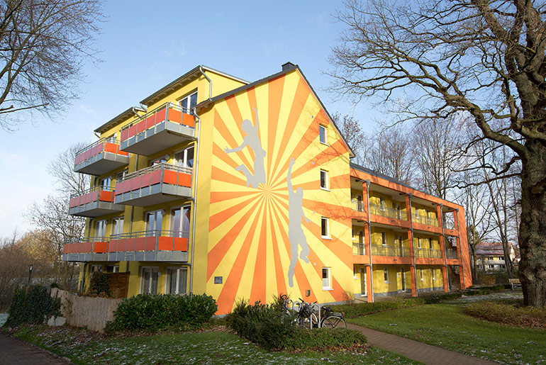 Außenansicht eines Studentenwohnheims mit gelb-roter Fassade