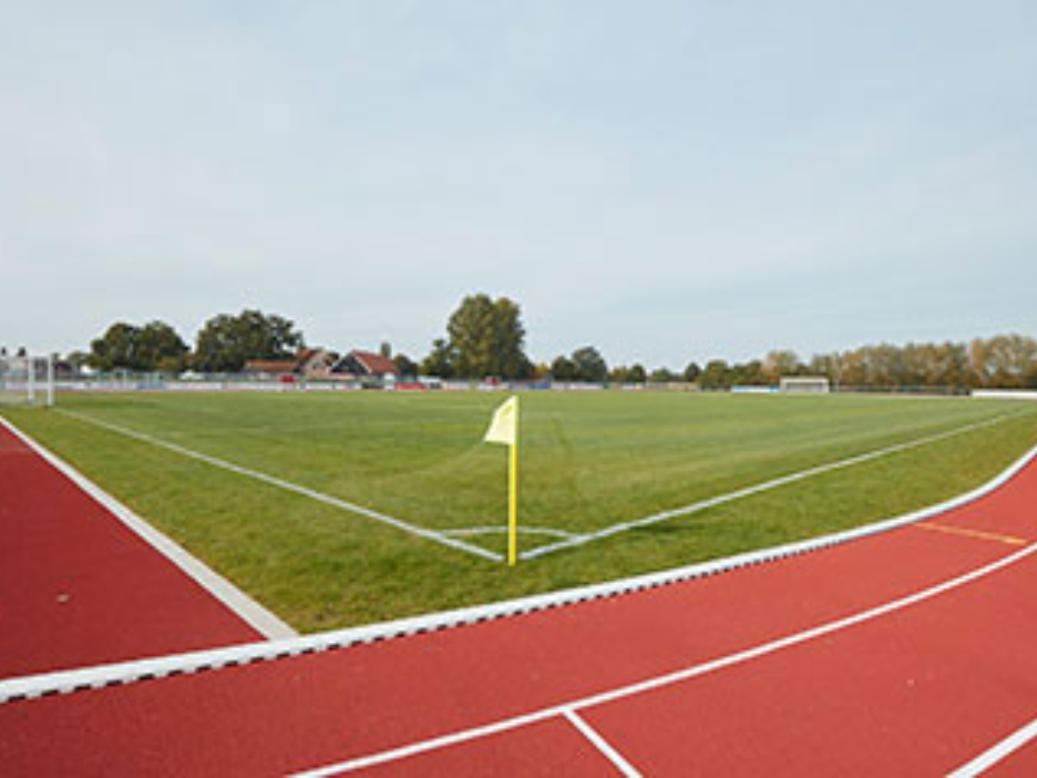 Fußballplatz, außen herum eine rote Laufbahn