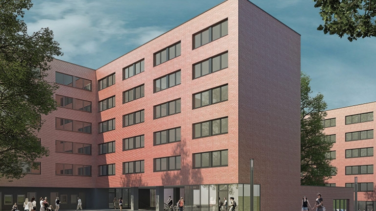 Gebäudekomplex eines Studentenwohnheims mit roter Fassade. Davor ein Platz mit Passanten