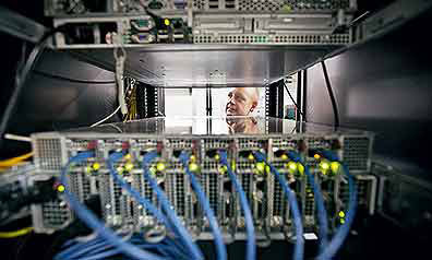 Ein Mann wirft einen Blick in eine elektrische Anlage mit vielen Kabeln
