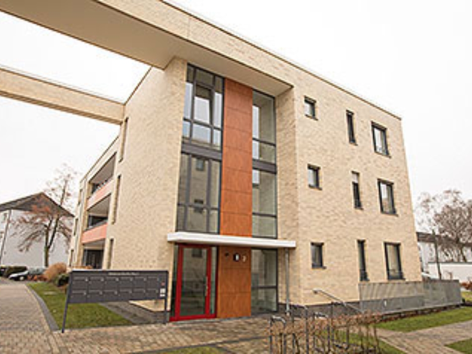 Eingangsbereich des Schützenhofs Lünen, ein modernes Wohnquartier, helle Fassade