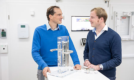 Tino und Dennis Konnertz, Geschäftsführer von Konntec, vor dem Modell eines Türschlosses