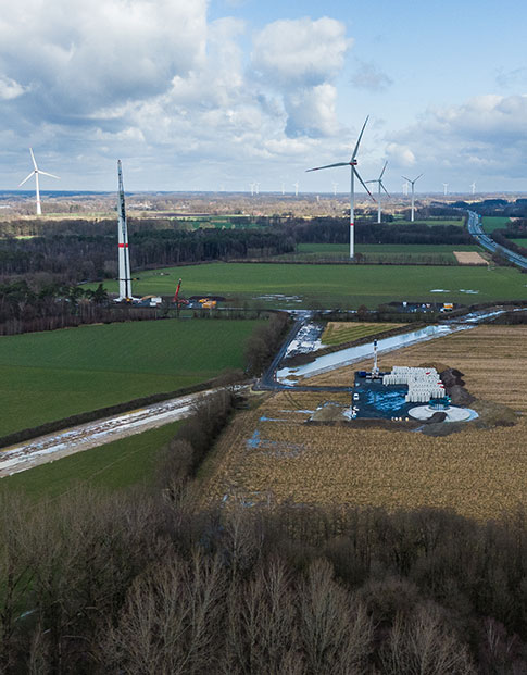 Zwei neue Windkrafträder werden auf einem Feld gebaut.