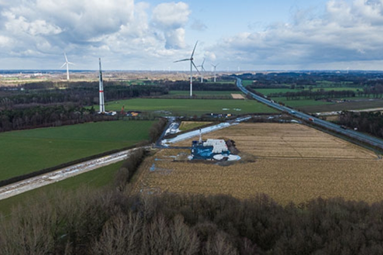 Zwei neue Windkrafträder werden auf einem Feld gebaut.