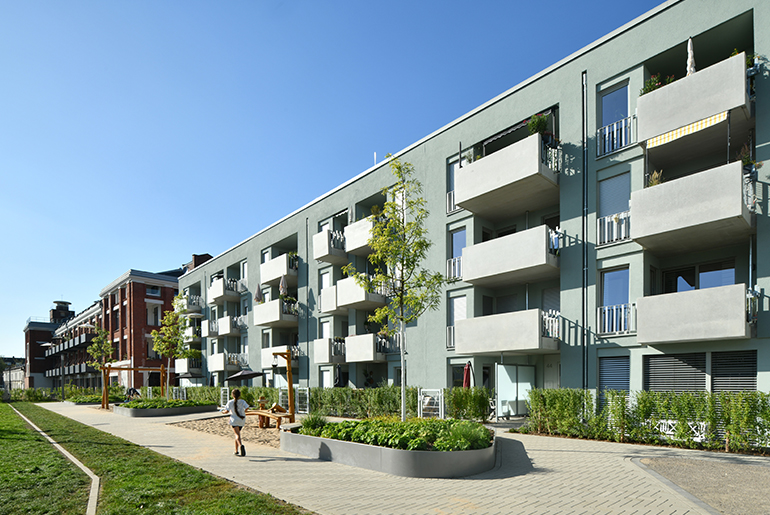 Hausfassade des neuen Clouth Quartiers mit Balkonen und einem Spielplatz