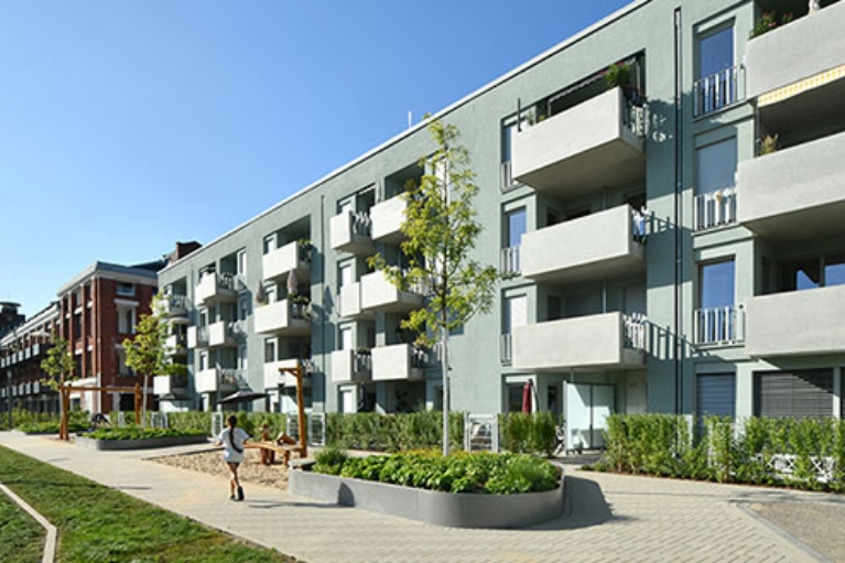 Hausfassade des neuen Clouth Quartiers mit Balkonen und einem Spielplatz