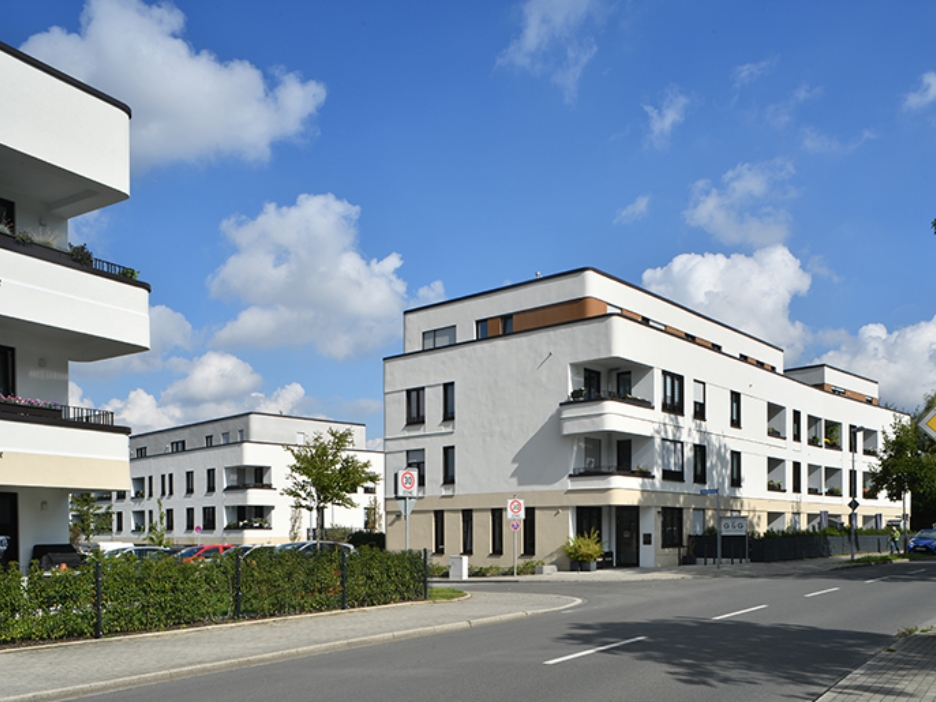Eine Neubausiedlung mit heller Fassade und abgerundeteten Ecken