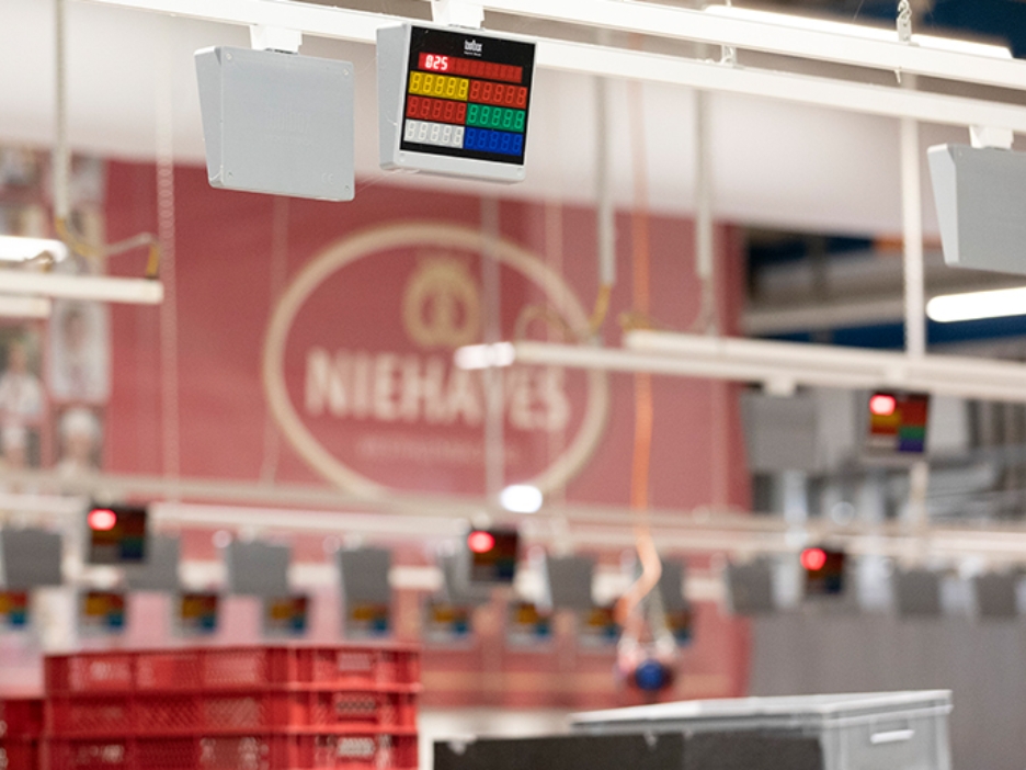 Ein digitales Display hängt an der Decke der Produktionshalle und hilft beim Versand an die Filialen.