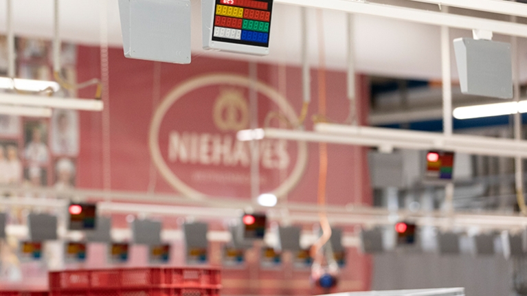 Ein digitales Display hängt an der Decke der Produktionshalle und hilft beim Versand an die Filialen.