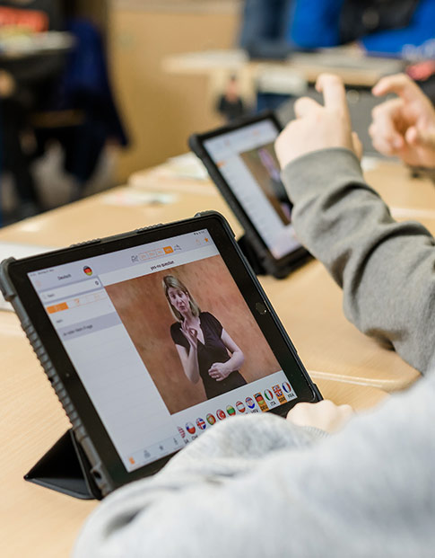 Schüler schauen sich im Unterricht etwas auf ihren Tablet-Computern an.