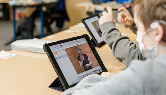 Schüler schauen sich im Unterricht etwas auf ihren Tablet-Computern an.