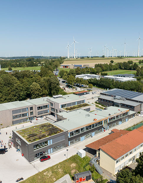 Großes Schulgelände mit mehreren Gebäuden mit Dachbegrünung und Solarpanels