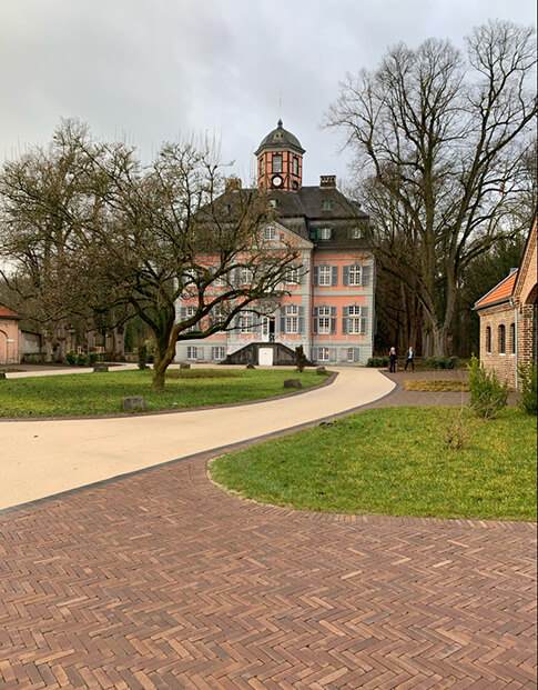 Außenansicht des Barockschlosses Arff in Köln mit Parkanlage im Vordergrund