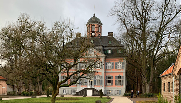 Außenansicht des Barockschlosses Arff in Köln mit Parkanlage im Vordergrund