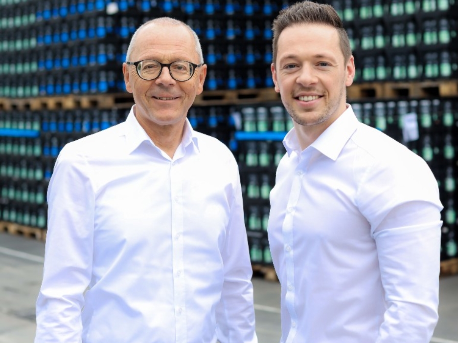 Die Geschäftsführer der Stiftsquelle, Michael und Sebastian Brodmann, vor ihrem Lager mit Wasserkästen.